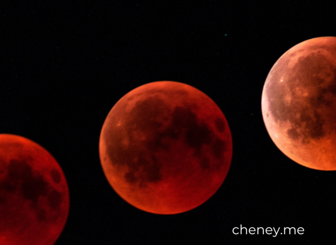 Three moons in various shades of red on a black background.