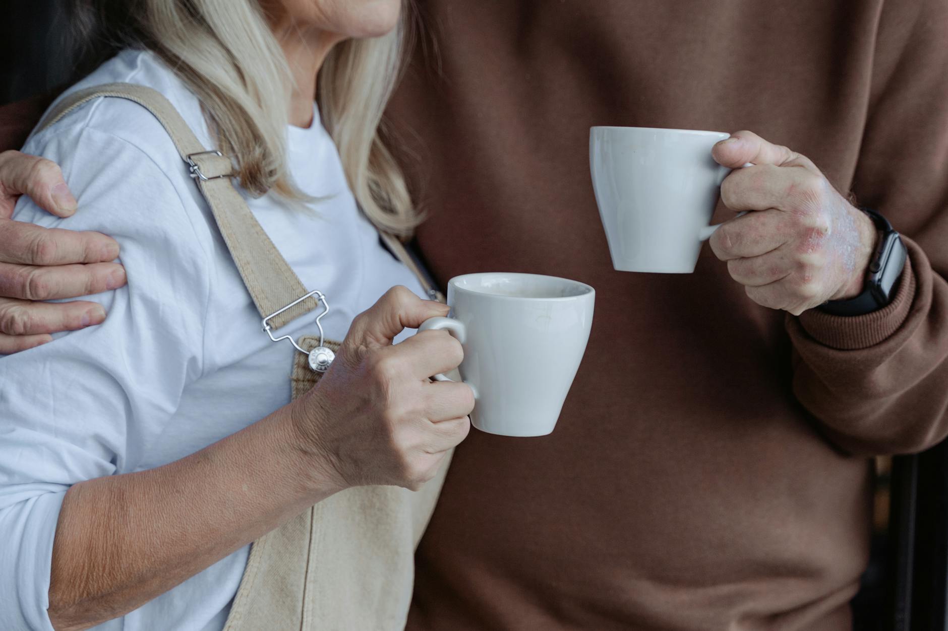 people holding white mugs