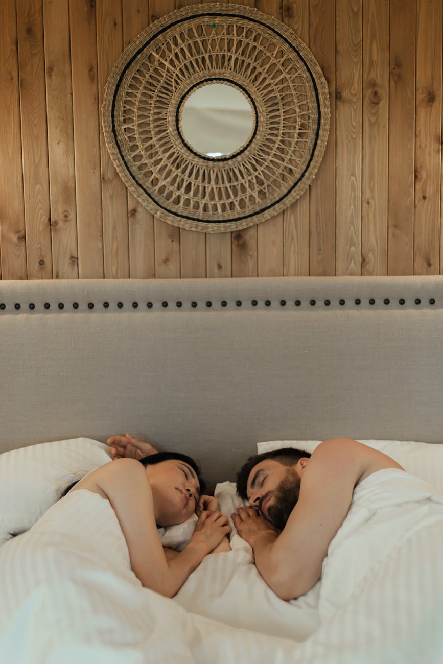romantic couple lying on bed while sleeping